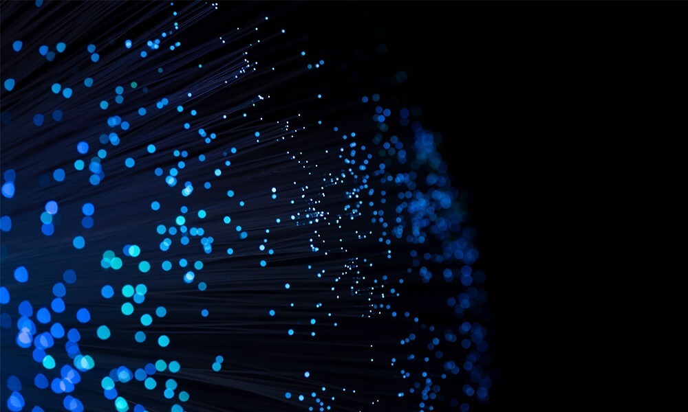 Abstract image of blue fiber optic lights representing high-speed data technology and connectivity.
