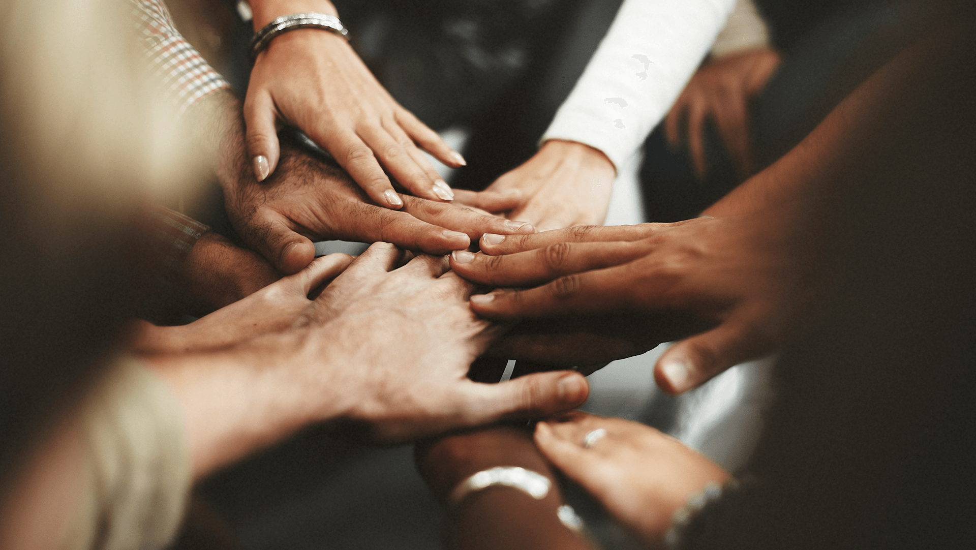 Unity in diversity: hands of different people coming together in a show of teamwork and solidarity.