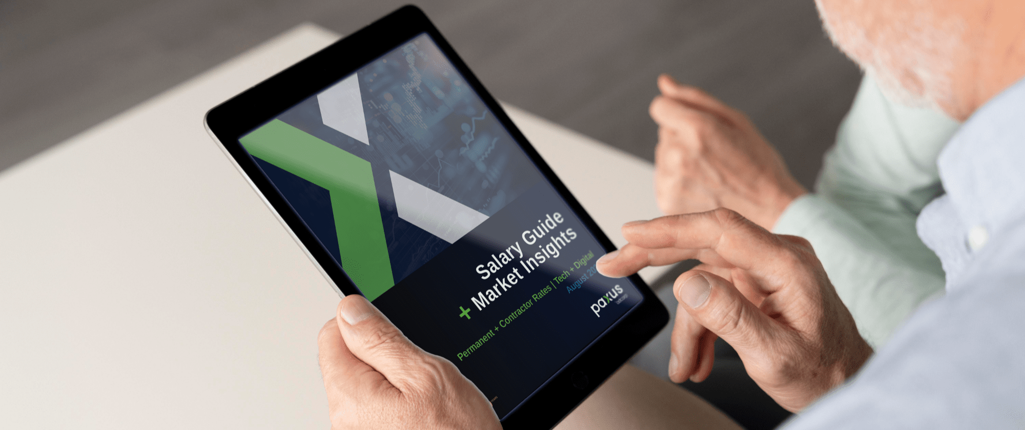A person holds a tablet displaying a report titled "Salary Guide + Market Insights" by PONTEM. The screen shows a green and white design with text. The person is using their finger to navigate the tablet.